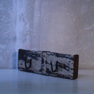 kapstok van verweerd wit hout met twee ijzeren haken