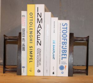 Rijtje boeken met 2 Franse vintage strijkijzers. Gebruikt als boekensteunen.