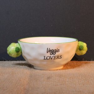 Wit porseleinen kom met groene rand, artisjok accenten en tekst Veggie Lovers