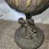 Brocante bronzen olielamp waarvan de voet bewerkt is met een cherubijn