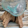 Handgemaakte bolvaas van gerecycled glas op wortelhout
