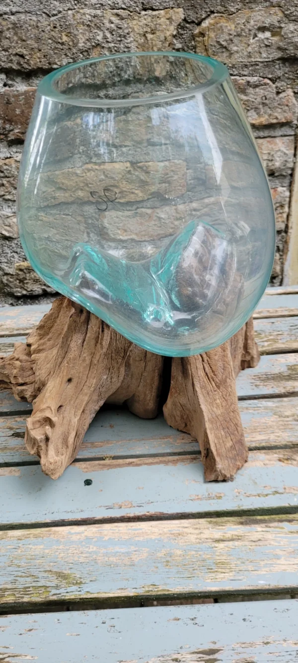 Handgemaakte bolvaas van gerecycled glas op wortelhout